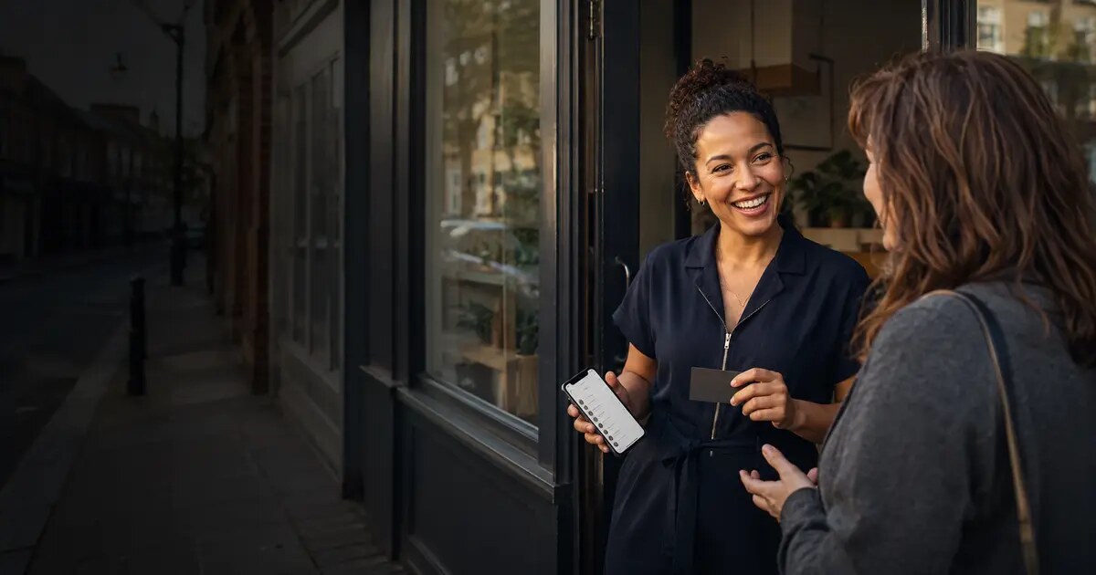 UK small-business owner speaking with one of her first customers outside an independent shop